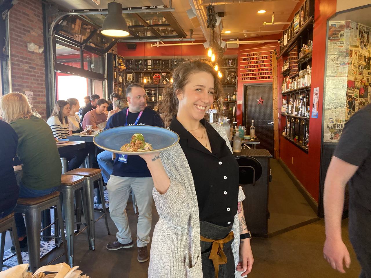A picture of the waitress serving tacos.
